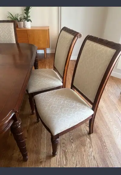 Elevate your dining experience with these elegant, used dining chairs, featuring a classic wood fram...