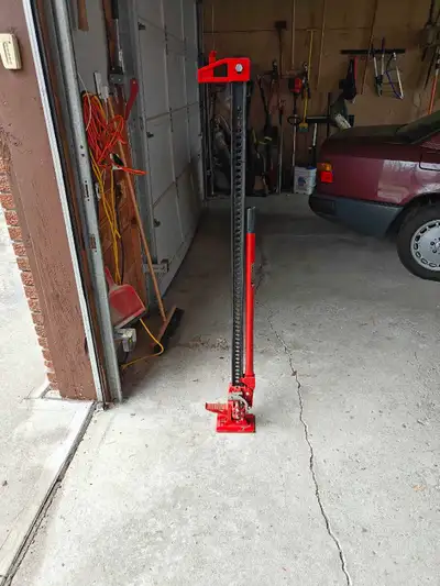This is a red farm jack, also known as a high lift jack, perfect for lifting heavy equipment or vehi...