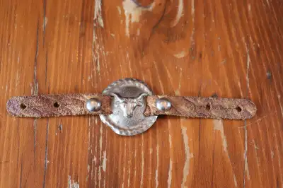 Hi. I have a vintage decorative medallion off an old child's holster set for sale. It has a leather...