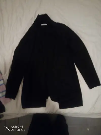 This is a stylish black cardigan in women's size M. It's been worn, but still in good condition, rea...