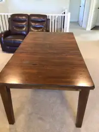 Solid wood dining table with retractable leaf
