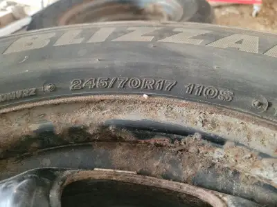 Bridgestone BLIZZAK Winter Tires - 245/70R17 110S; Steel Rims with Chevy (Traverse) caps and lugs. G...