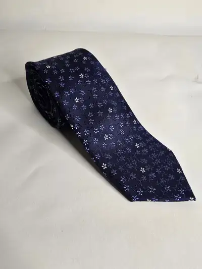 Ted Baker silk tie, featuring a refined floral pattern in soft blues and whites against a deep navy...