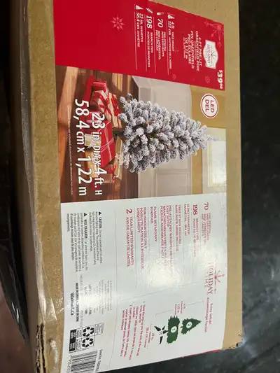 4ft pre-lit artificial Christmas tree. 70 mini LED lights. 23in diameter. Includes tree stand. Easy...