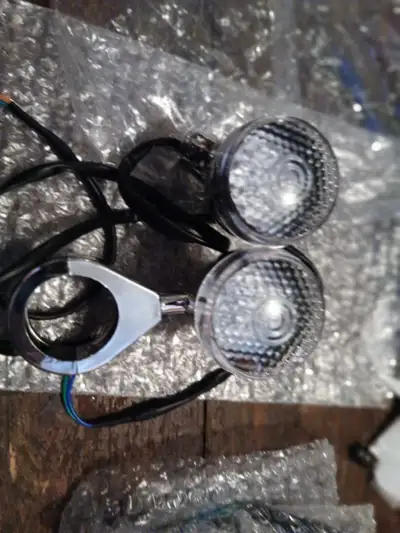 Harley- Softail signal lights, 2006 and older NEW in the package. C/W 41 mm fork tube clamps and rea...