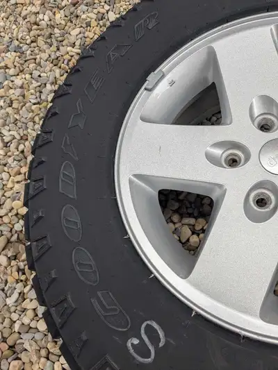 This set of 5 Goodyear Wrangler tires, size 255/75R17, are mounted on factory Jeep alloy wheels and...