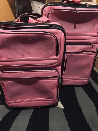 Set of 2 pink rolling luggage in decent condition. Has a lot of wear and tear but still useable. Sel...