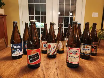 Thirteen large (625 ml) empty vintage beer bottles, commonly referred to as quart bottles. Ten of th...