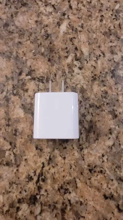 White Apple USB-C power adapter with a USB-C to USB-C cable. It's a 20W adapter for fast charging. C...