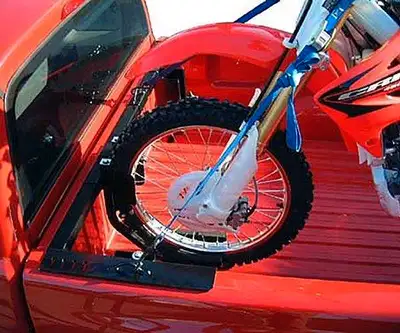 Truck bed rack for hauling motocross/dirt bikes/etc. Has two adjustable wheel shocks to securely hol...
