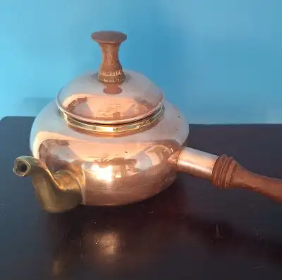 charming vintage tea copper pot featuring a dark wooden handle and a matching lid. The pot is made o...