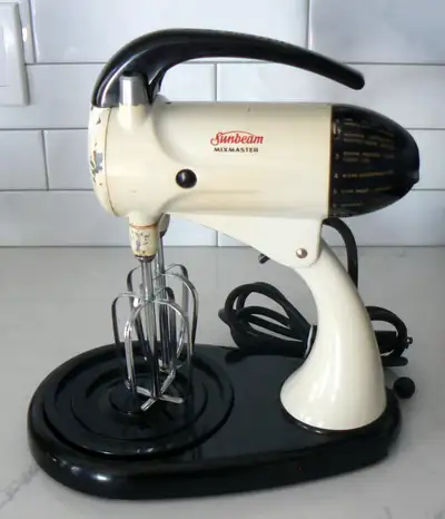 This is a 1960 12 speed Sunbeam Stand Mixmaster with the original 2 milk white glass bowls and 2 bea...