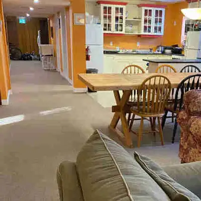 Large furnished room with queen size bed, desk, dresser, shelving and chairs in newly renovated buil...