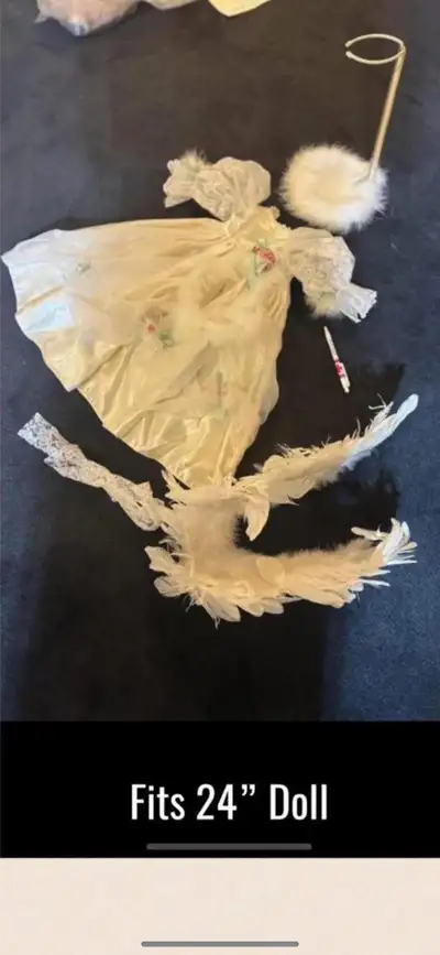 This is a darling, cream-coloured angel costume for a 24-inch doll, complete with feathered wings an...