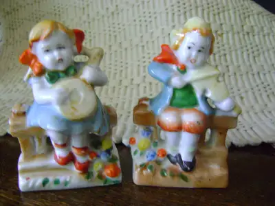 THE GIRL IS PAYING WHAT LOOKS LIKE A BANJO SITTING ON A FENCE OR A RAILING. THE BOTTOM IS STAMPED K...