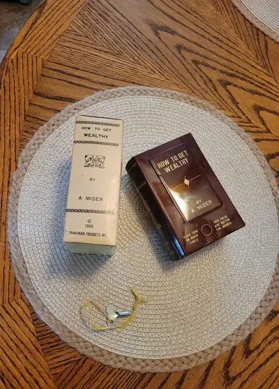 Uncover vintage charm with this 1968 Yanoman Secret Coin Bank, a delightful "How to Get Wealthy" boo...