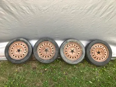 Three “205/55R16” Firestone and one Hankook tires mounted on 5 x 114.3” steel rims. Tires have a sea...
