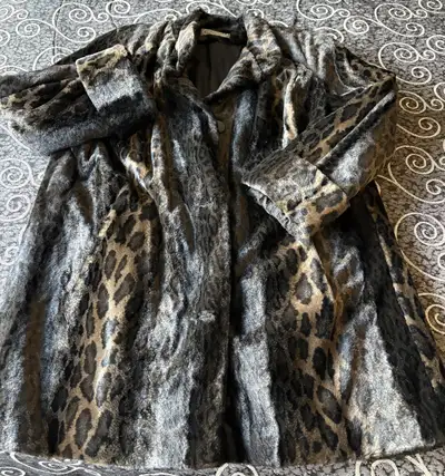This Novelti leopard print coat is a striking statement piece, perfect for adding a touch of wild el...