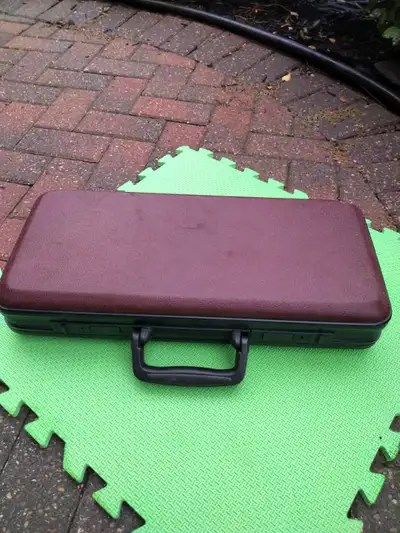 Cloth-lined hard shell locking briefcase. About half size of normal briefcase. Secured with double l...