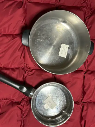 Two stainless steel kitchen cooking pots, ready for your culinary adventures! The larger pot measure...
