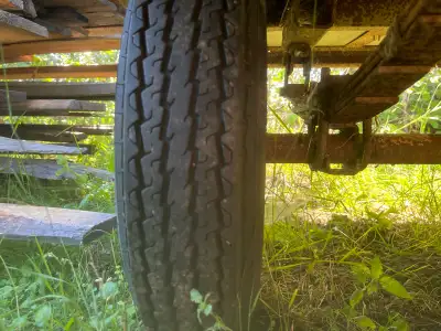 This used single-axle utility trailer features a sturdy wood floor and a manual hand winch for conve...
